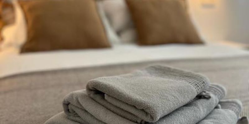 Detalle de toallas encima de cama matrimonial